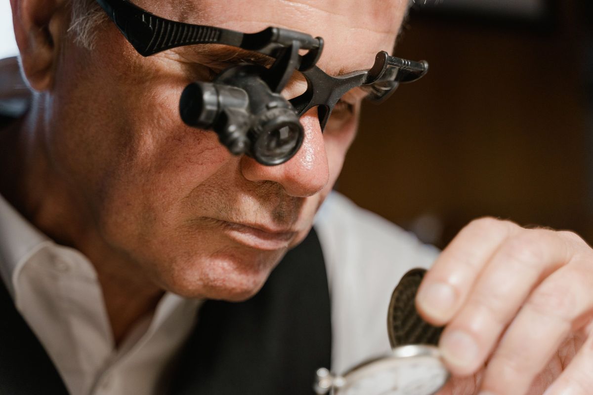 A jeweller checking a finished ring through a head loupe