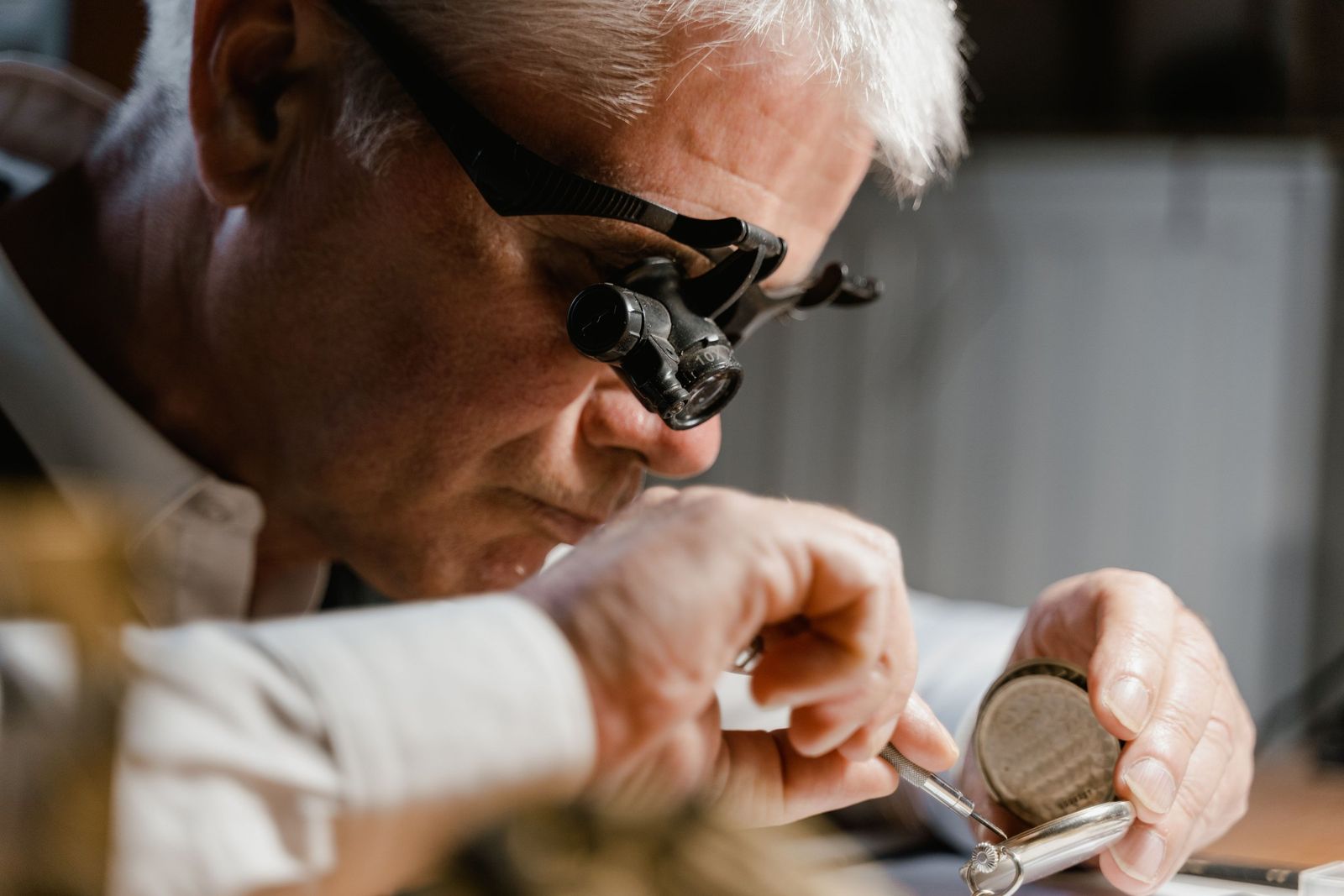 Arthur Hale checking a finished ring through his double head loupe