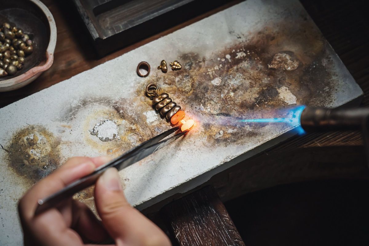 A torch flame soldering platinum on a charcoal block