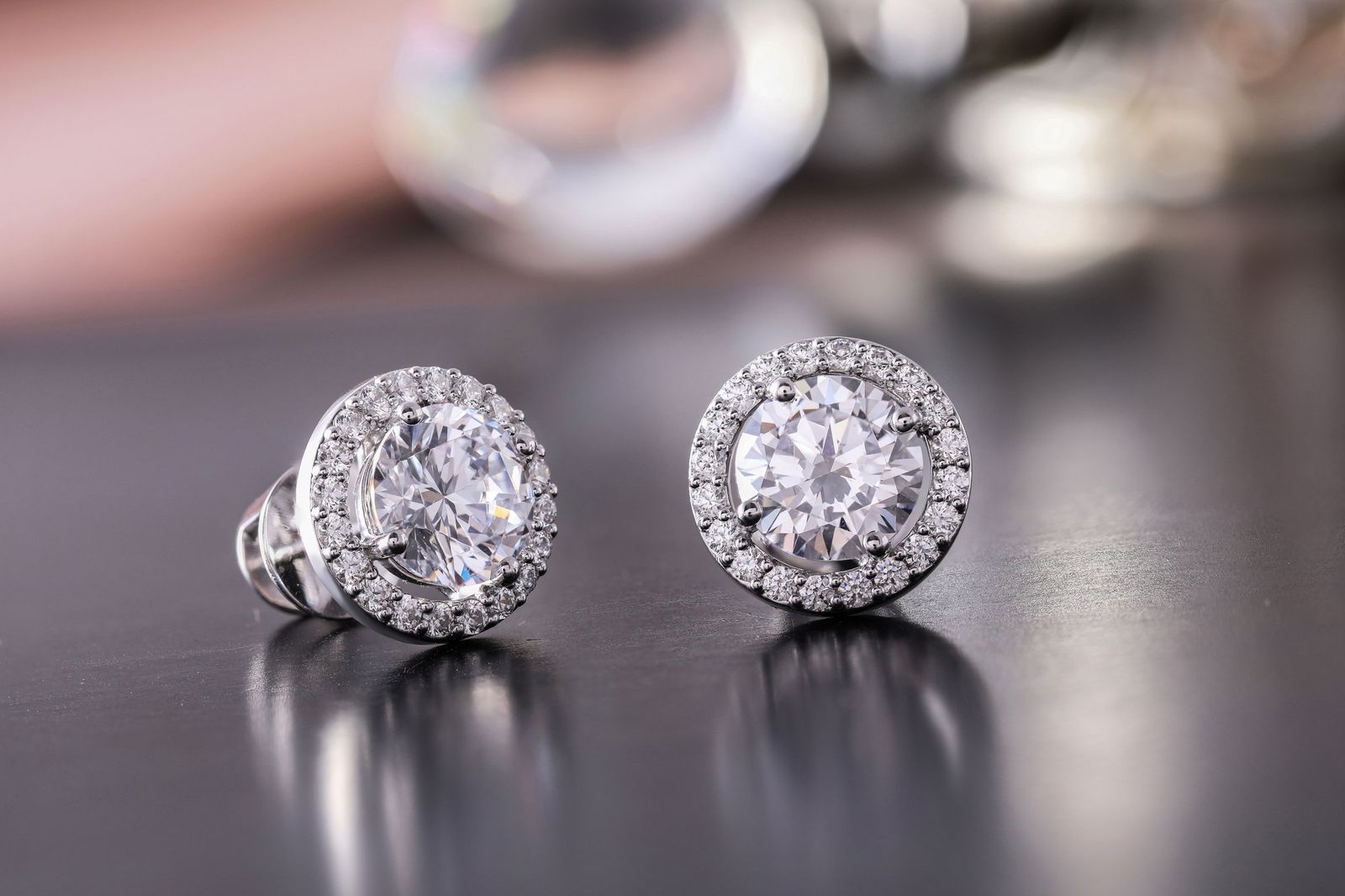 A pair of round halo diamond earrings