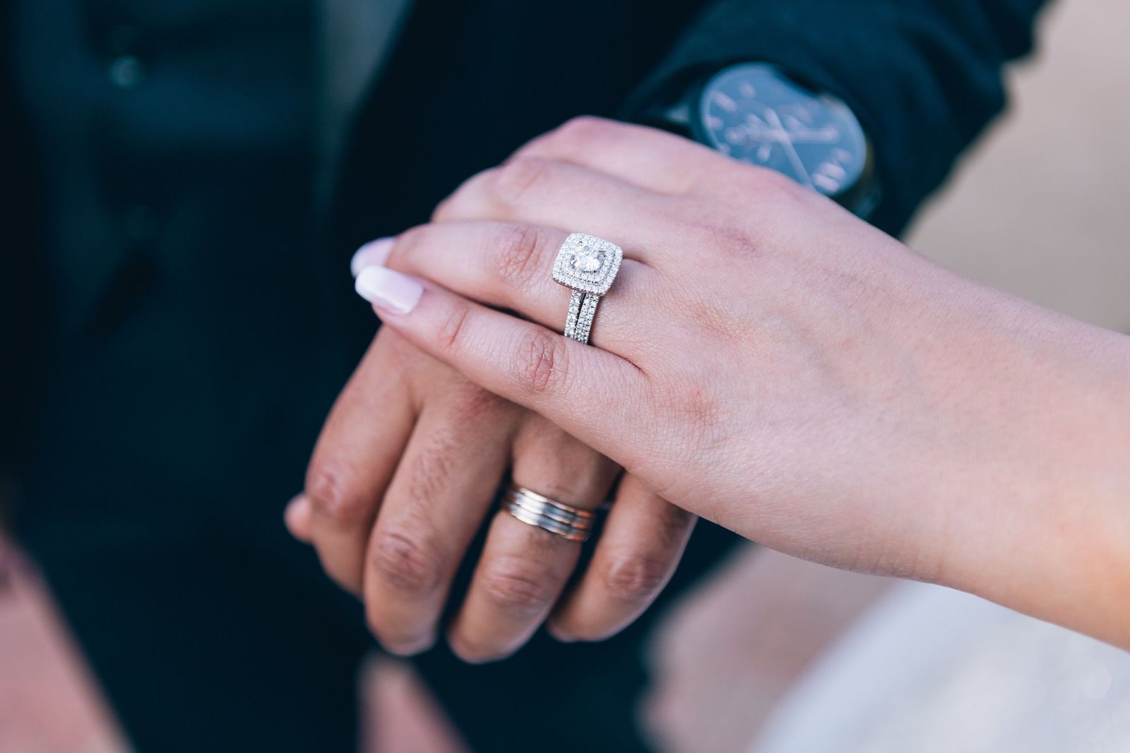 Two hands, one wearing a new engagement ring